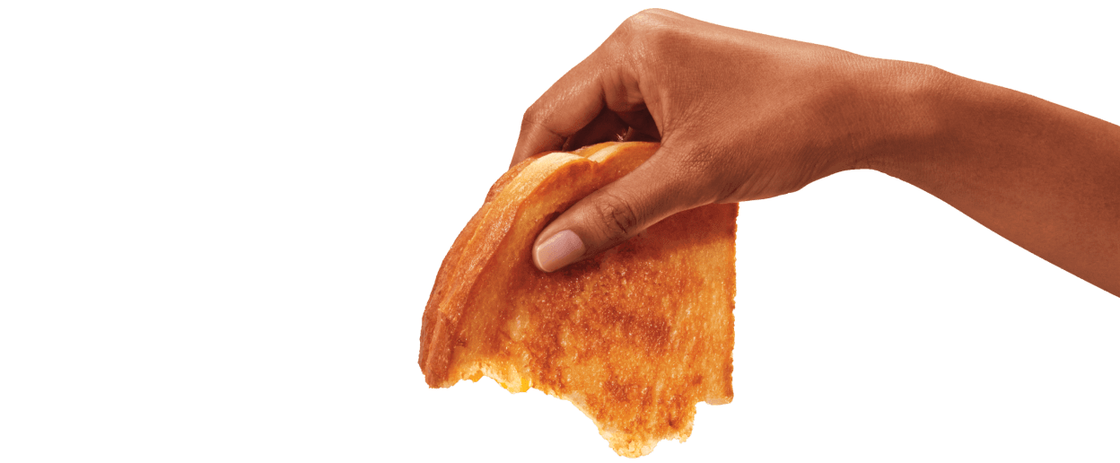 hand holding a half eaten grilled cheese sandwich
